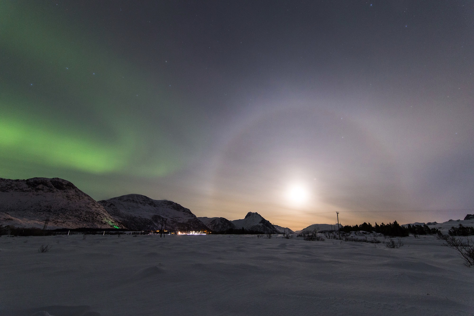 Noorderlicht en een halo rond de maan op de Lofoten